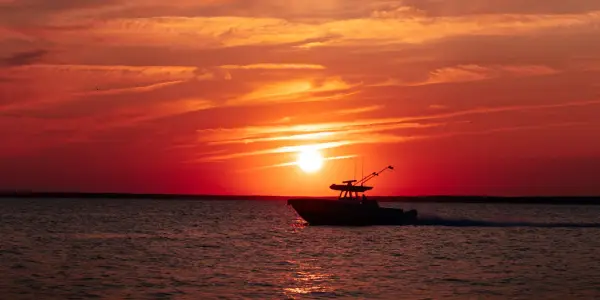 Fishing boat cruising during sundown in buzzards bay, MA